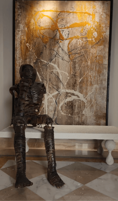 Metal figure sculpture and painting in a finished interior
